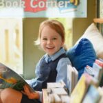 A happy child reading in Reception