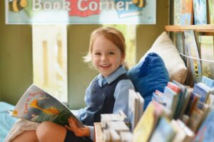 A happy child reading in Reception